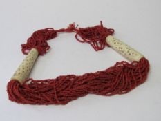 Coral beaded necklace with bone accessories. Estimate £10-20.