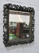 Bevel edge mirror in highly ornate carved foliage frame, approx 90cms x 82cms. Estimate £100-120.