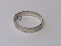 A silver hinged bracelet with engraved decoration, London 1963, wt 0.76ozt. Estimate £30-40.