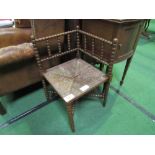 Bobbin turned corner seat with string seat. Estimate £15-25.