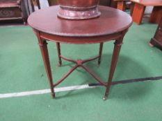 Circular mahogany table on tapered legs to castors, diameter 76cms. Estimate £10-20.