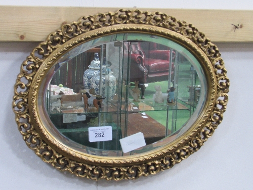 Oval gold open worked frame wall mirror. Estimate £20-30.