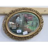 Oval gold open worked frame wall mirror. Estimate £20-30.