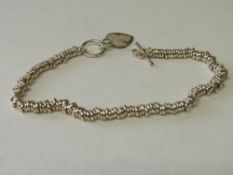 Sterling silver Sweetie bracelet with silver heart fob. Estimate £15-25.