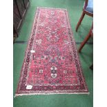 Red ground patterned runner, 214 x 84. Estimate £10-20.