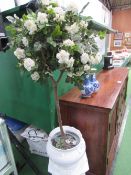 White ceramic jardinere on stand c/w artificial rose bush. Estimate £20-30.