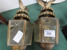 Pair of brass carriage lamps with eagle mounts (1 with 2 cracked panes of glass). Estimate £40-50.