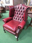 Leather wing back button back armchair. Estimate £50-70.