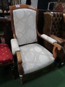 French walnut upholstered open arm chair with castors. Estimate £30-40.