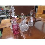 3 cut glass decanters, cut glass claret jug & a ruby coloured cut glass decanter, a/f. Estimate £