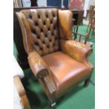 Leather button back wing backed arm chair. Estimate £40-50.