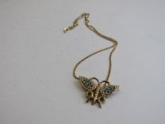 9ct gold butterfly pendant decorated with green & red stones on a 9ct gold chain, total weight 7.