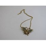 9ct gold butterfly pendant decorated with green & red stones on a 9ct gold chain, total weight 7.