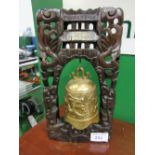 Oriental brass bell in ornately carved stand (temple bell), height 45cms. Estimate £50-100.