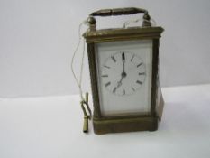 Brass cased carriage clock with visible escapement c/w key. Estimate £40-60.