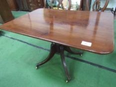 Regency mahogany tilt-top breakfast table on pedestal to 4 legs on brass castors, 121cms x 85cms x