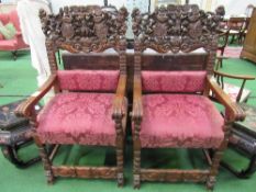 2 oak open armchairs with highly ornate carved backs depicting animals, figures, scrolls, known as