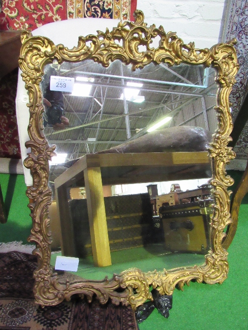 Plaster & wood framed ornately decorated gilt framed wall mirror, 90cms x 63cms. Estimate £50-100.