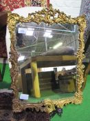 Plaster & wood framed ornately decorated gilt framed wall mirror, 90cms x 63cms. Estimate £50-100.