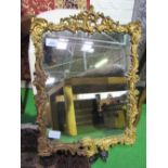 Plaster & wood framed ornately decorated gilt framed wall mirror, 90cms x 63cms. Estimate £50-100.