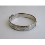 Silver hinged bracelet with engraved decoration, London 1963, weight 0.76ozt. Estimate £20-30.