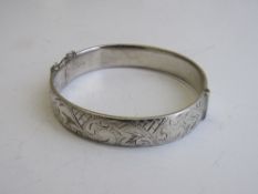 Silver hinged bracelet with engraved decoration, London 1963, weight 0.76ozt. Estimate £20-30.