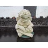 Moulded stone-like Putto with book. Estimate £20-30.