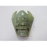 Jade belt buckle in the form of a mask. Estimate £20-30.