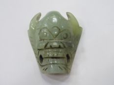 Jade belt buckle in the form of a mask. Estimate £20-30.