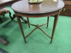 Circular mahogany table on tapered legs to castors, 76cms diameter. Estimate £10-20.