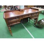 Mahogany writing desk on turned legs to casters, 122cms x 57cms x 77cms. Estimate £80-100.