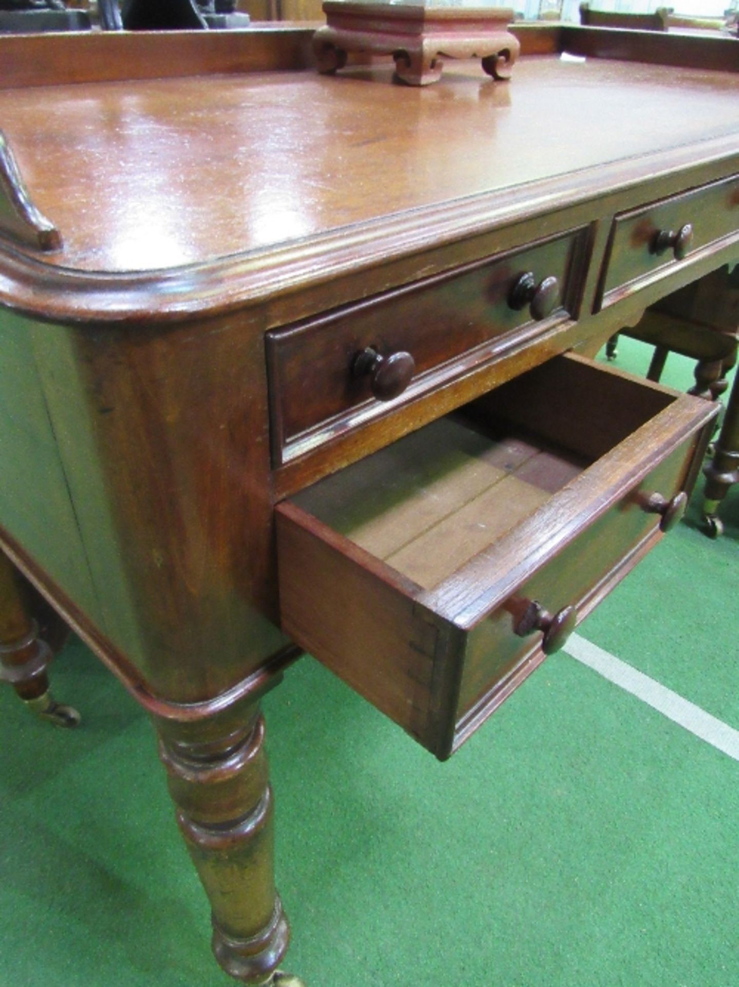 Mahogany writing desk on turned legs to casters, 122cms x 57cms x 77cms. Estimate £80-100. - Image 2 of 4