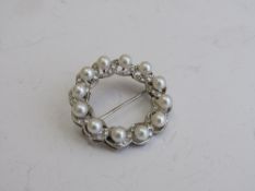 Tested white gold pearl & diamond circular brooch, 3.3cms diameter. Estimate £500-600.