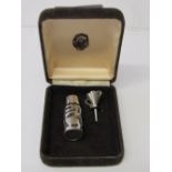Sterling silver perfume bottle & funnel in a case. Estimate £30-40.