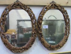 A pair of carved wood framed oval mirrors with birds & foliage. Estimate £100-150.