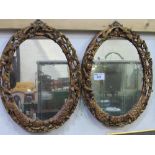 A pair of carved wood framed oval mirrors with birds & foliage. Estimate £100-150.