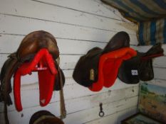 3 leather saddles and racks