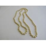 String of golden coloured pearls, length 76cms. Estimate £250-300.