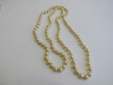 String of golden coloured pearls, length 76cms. Estimate £250-300.