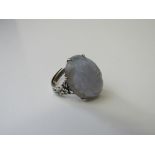 Chinese silver ring set with an oval purple hard stone (possibly lavender jade) with floral