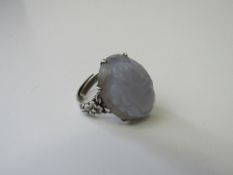 Chinese silver ring set with an oval purple hard stone (possibly lavender jade) with floral