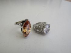 Silver orange oval-shaped ring & a silver & white stone ring. Estimate £10-20.