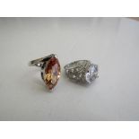 Silver orange oval-shaped ring & a silver & white stone ring. Estimate £10-20.