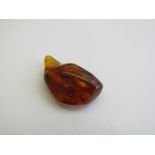 Piece of amber with natural specimens inside. Estimate £30-40.