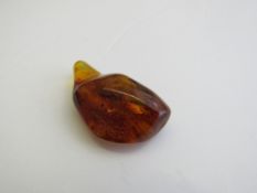 Piece of amber with natural specimens inside. Estimate £30-40.