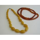Amber coloured necklace of round cylindrical beads & an amber coloured necklace. Estimate £20-50.