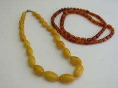 Amber coloured necklace of round cylindrical beads & an amber coloured necklace. Estimate £20-50.