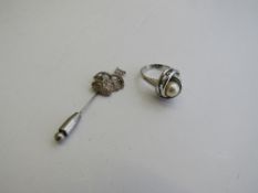 Stick pin decorated with galleon & a white metal & pearl ring, size O. Estimate £10-20.