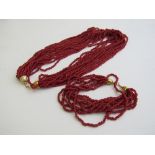 Red coloured coral like necklace & bracelet. Estimate £40-60.