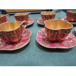 Set of 8 Coalport shamrock-shaped red & gold coffee cups & saucers. Estimate £30-40.